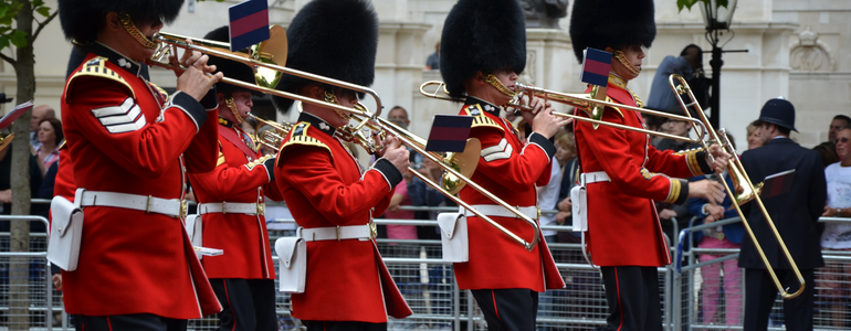 London guards blowing trumpets outside Buckingham Palace during festivities. 
