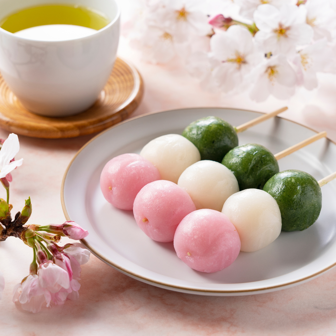 Hanami Dango (tri-colour Japanese dango) displayed on cherry blossom teaware with a cup of matcha green tea.