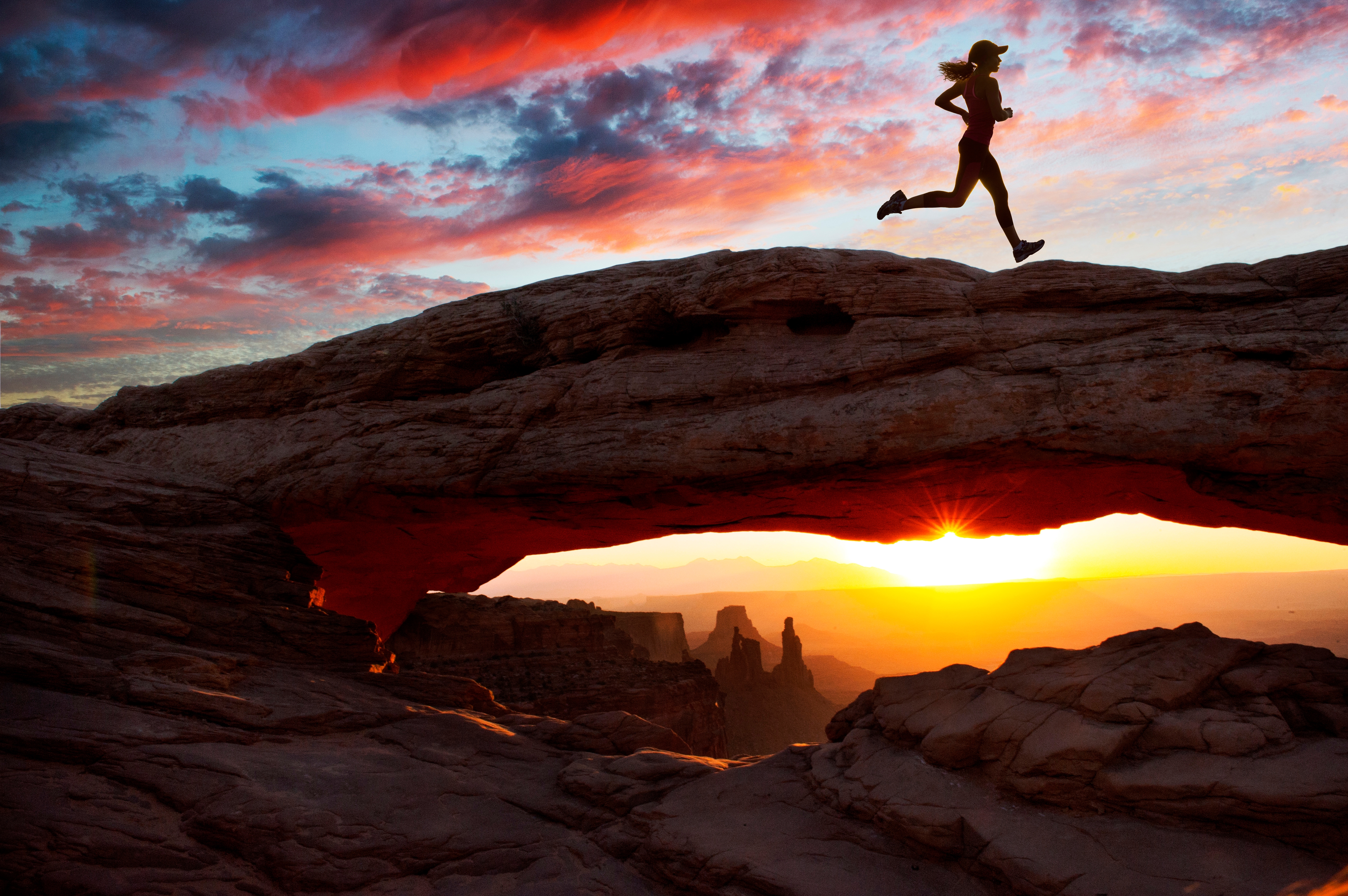 female running on rock in Utah at sunset