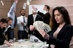 Women holding money in a celebrating office